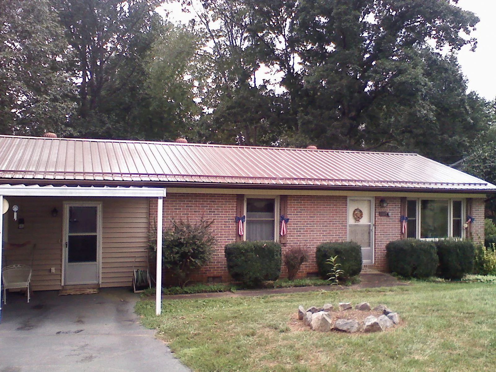 Bronze metal roof and carport on a brick ranch home — Roof Repair work by our crew in Millbury